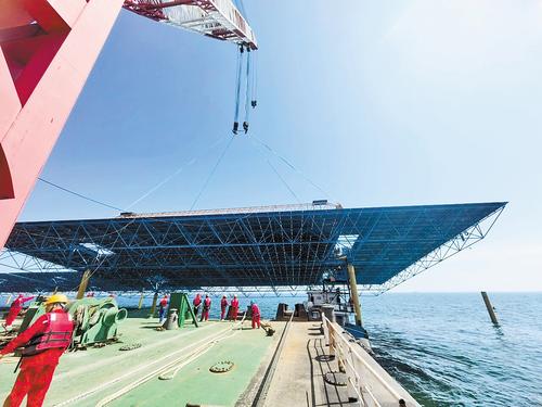 8月26日,在河北华电昌黎500兆瓦海上光伏试点项目现场,工人们正在吊装光伏板网架。 本报记者 孙也达摄
